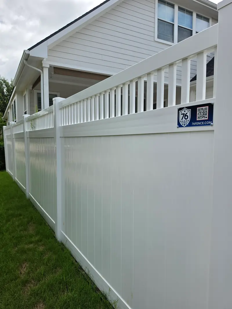 White vinyl privacy fence with an open picket top running along a side yard